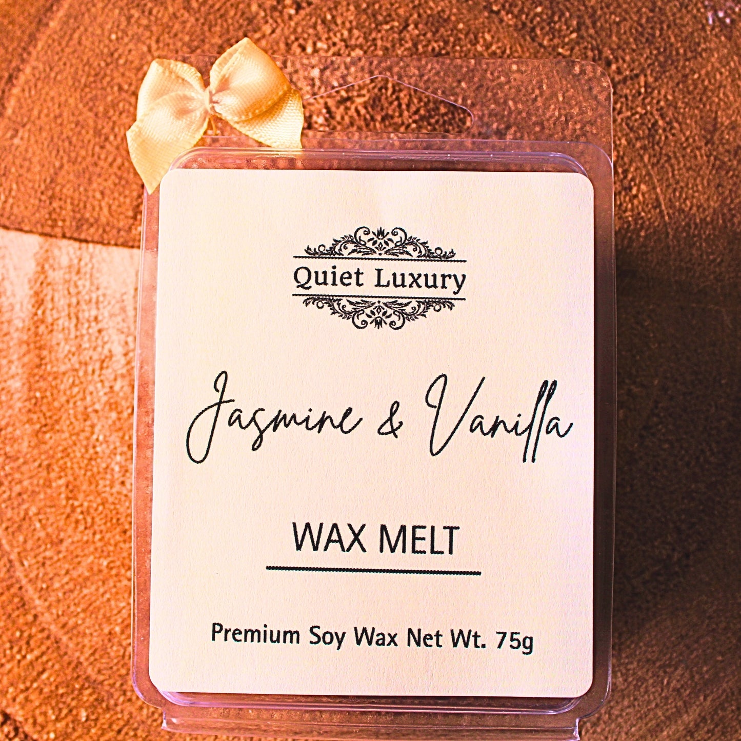 Jasmine and vanilla wax melt packaging with 'Quiet Luxury' branding on a wooden surface