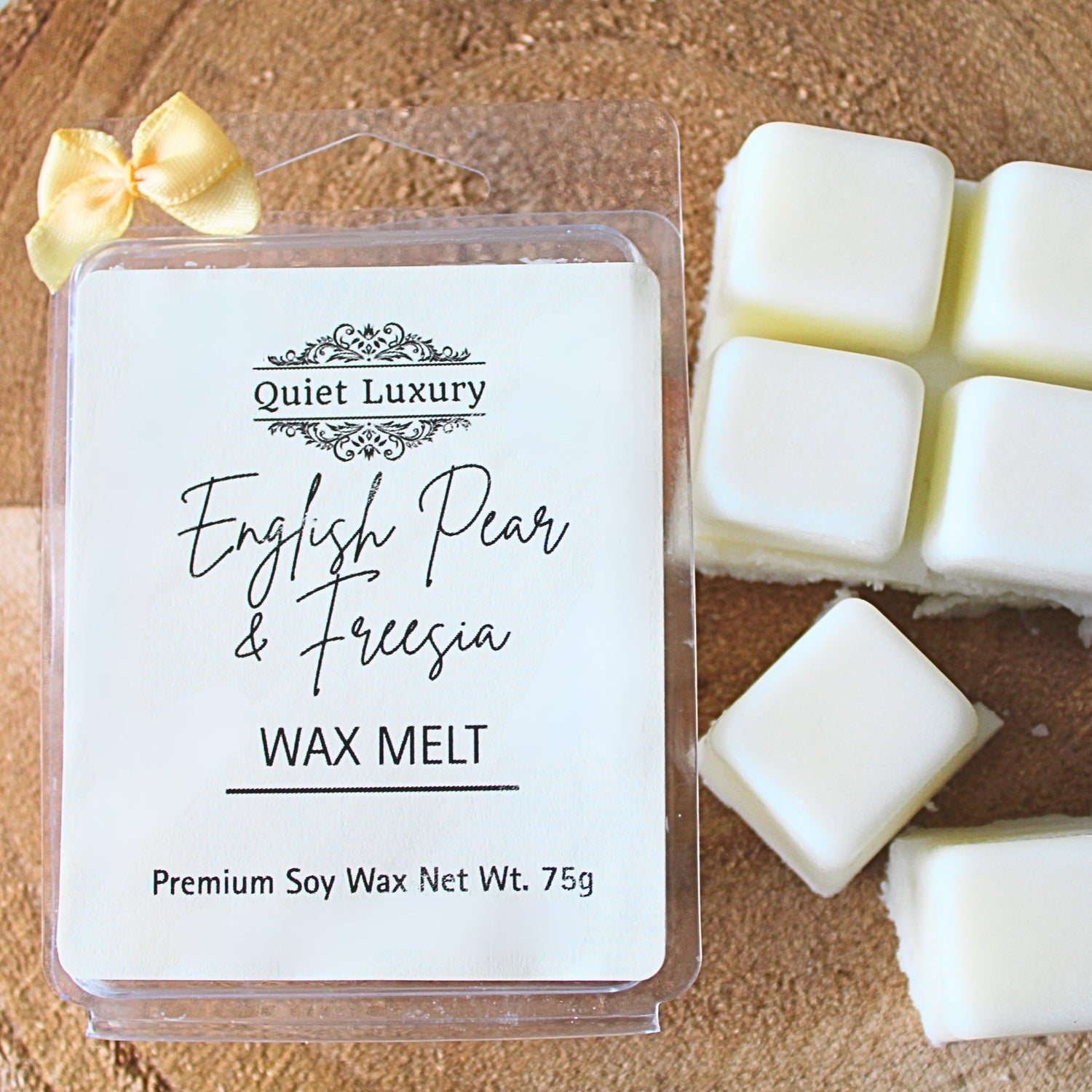 English pear and freesia soy wax melt pack with white wax cubes on wood surface