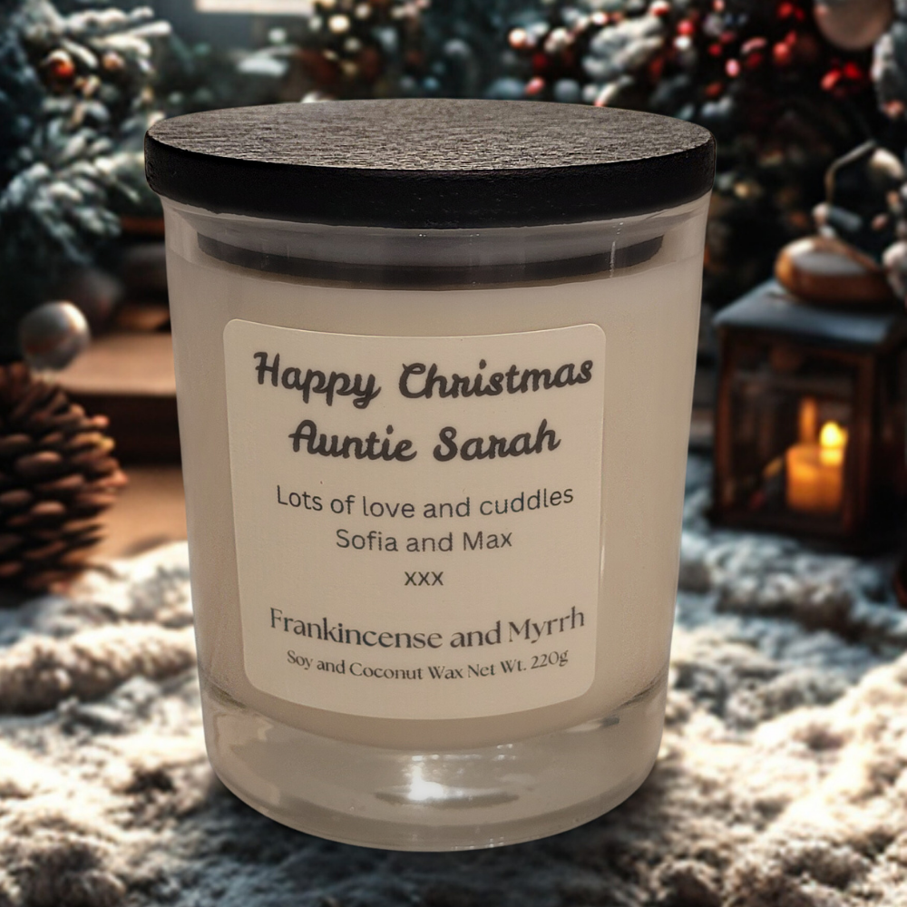 Personalised Christmas candle with 'Frankincense and Myrrh' label in festive setting