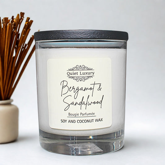 Candle labeled 'Bergamot & Sandalwood' by 'Quiet Luxury' with a black lid on a white background.