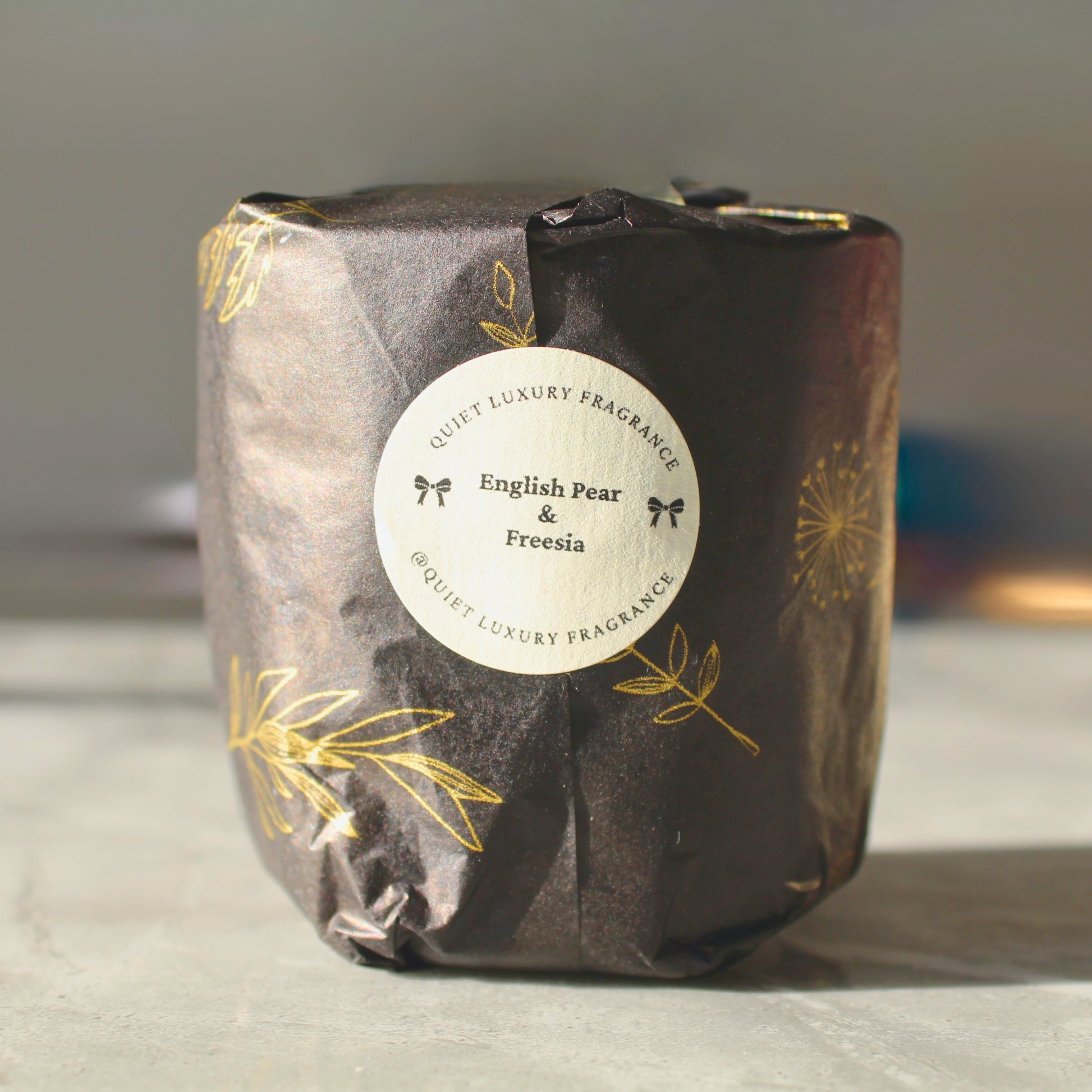 luxury wrapped candle refill with a label on a neutral background