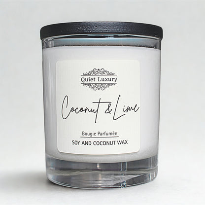 Coconut and lime scented candle in clear glass jar with black lid, soy and coconut wax