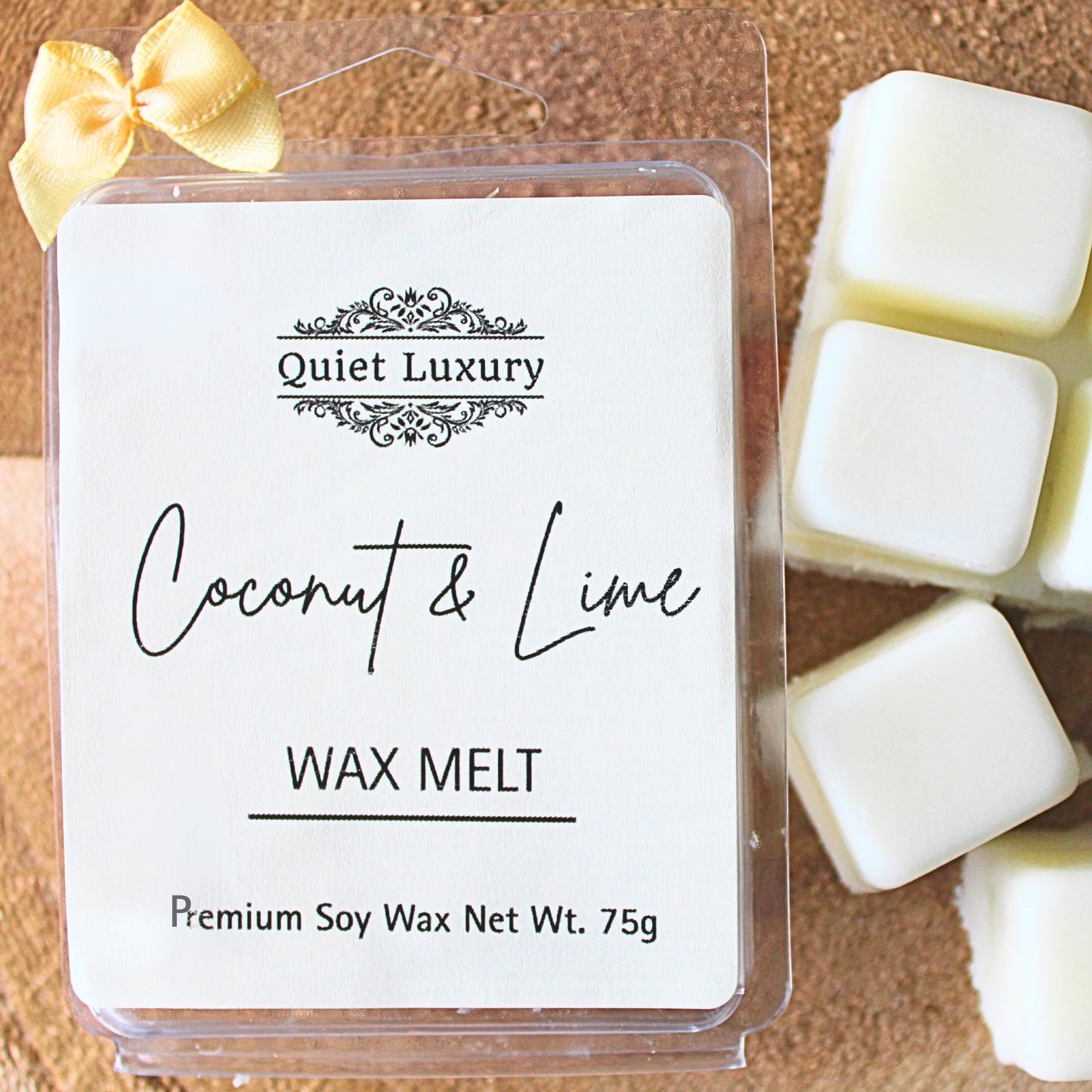 Coconut & Lime soy wax melt packaging with 'Quiet Luxury' branding on a wooden surface.