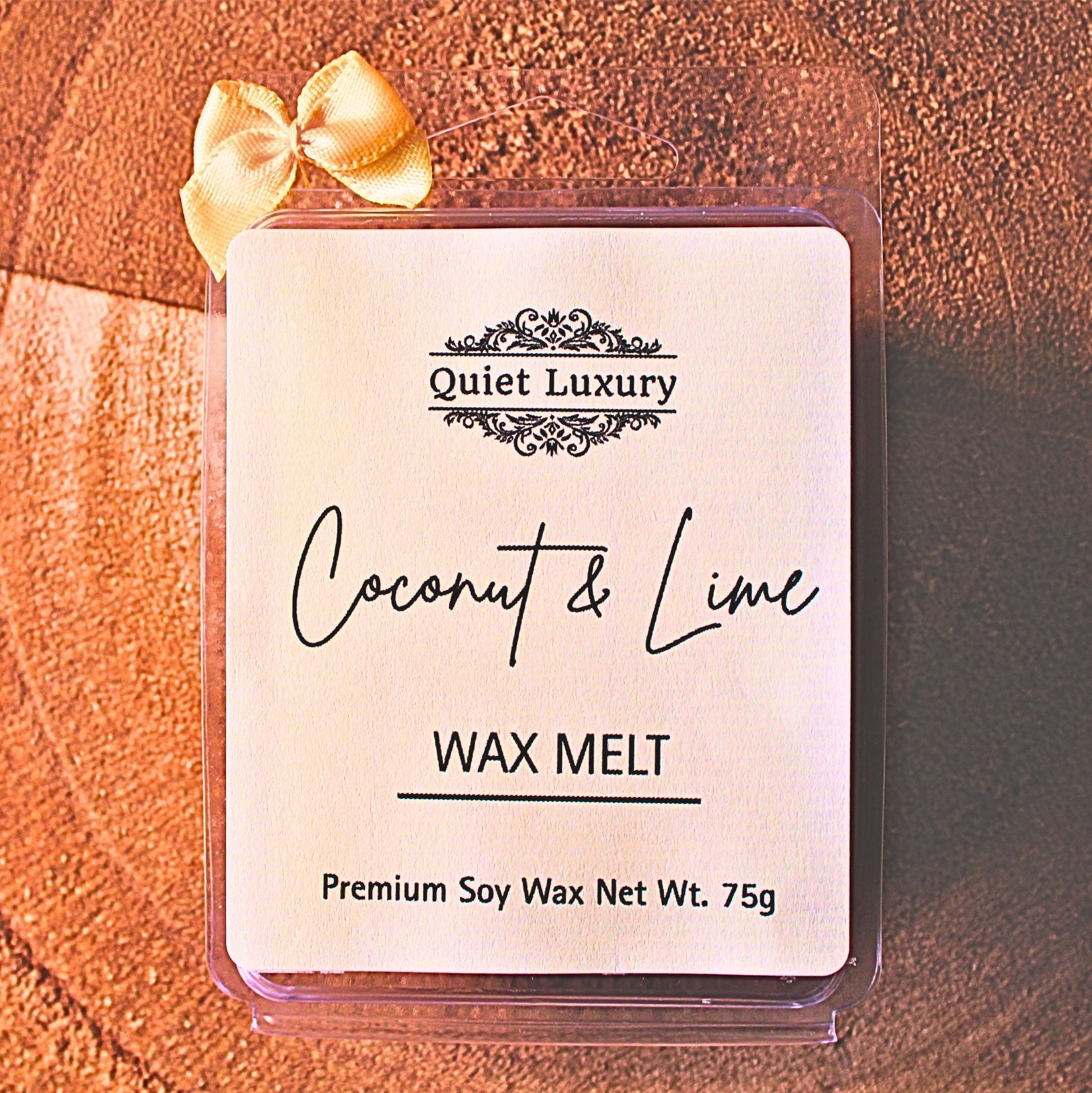 Coconut & Lime soy wax melt packaging with 'Quiet Luxury' branding on a wooden surface.