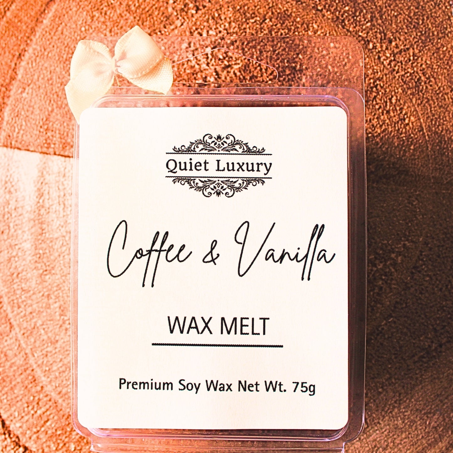 coffee and vanilla soy wax melt packaging with 'Quiet Luxury' branding on a wooden surface.
