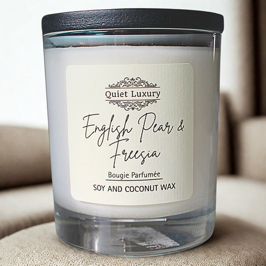 English pear and freesia Candle with 'Quiet Luxury' label on a beige surface
