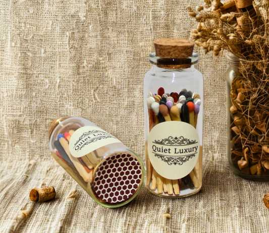 Jar of coloured luxury matches labeled 'Quiet Luxury' on a textured surface