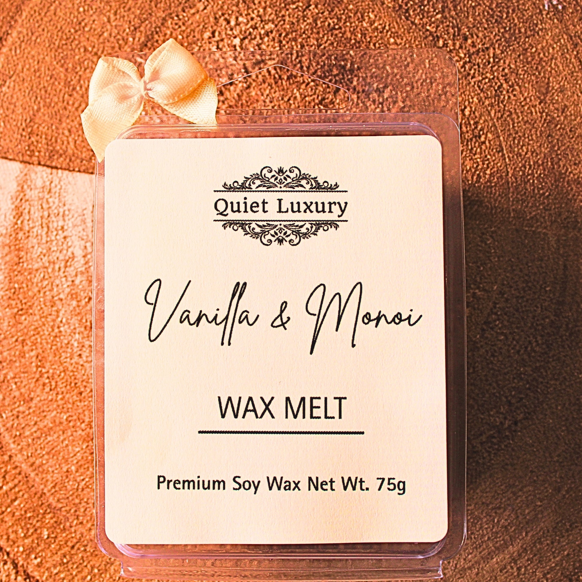 Vanilla and Monoi wax melt packaging with 'Quiet Luxury' branding on a textured brown background