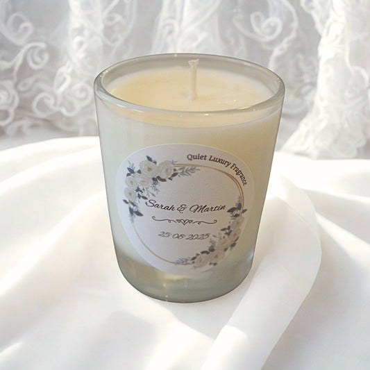 Wedding favour candle with a personalised label on a white fabric background