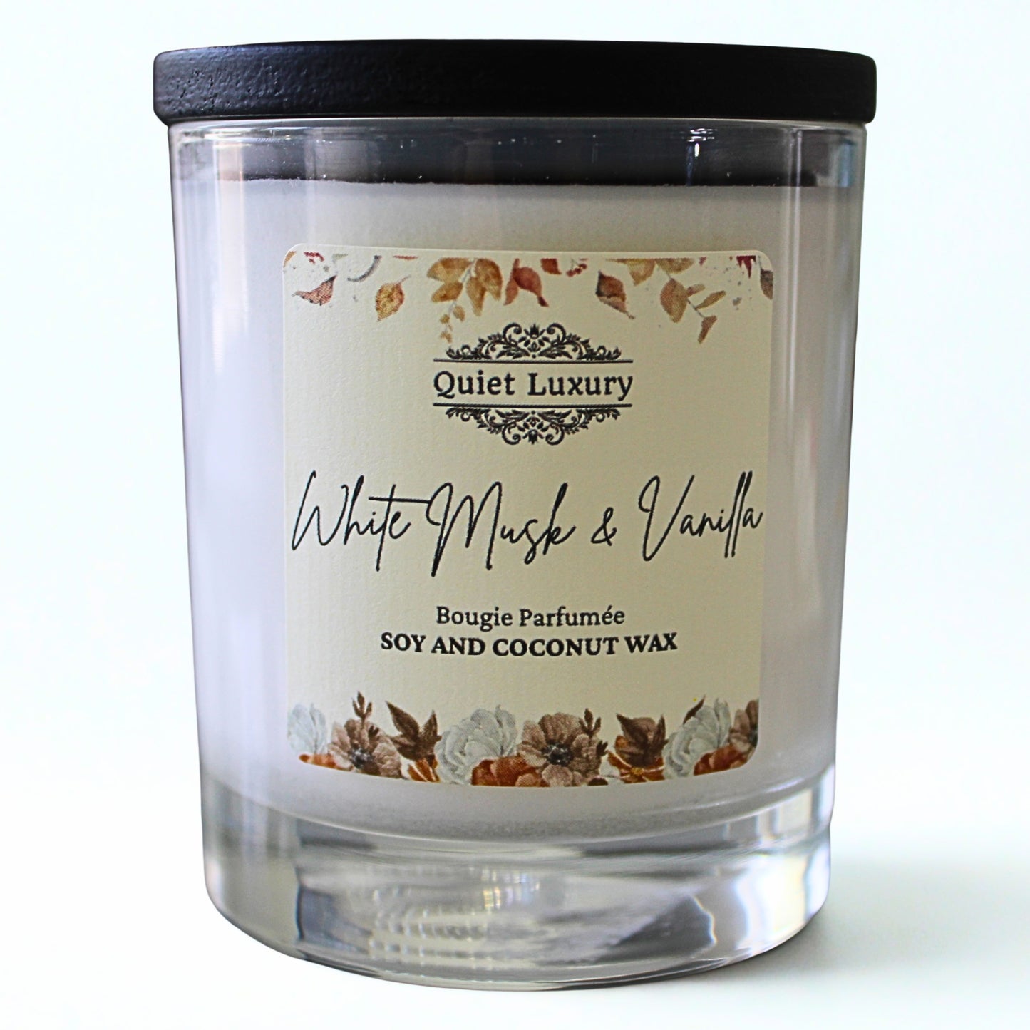 Candle with a label reading 'Quiet Luxury White Musk & Vanilla' on a white background