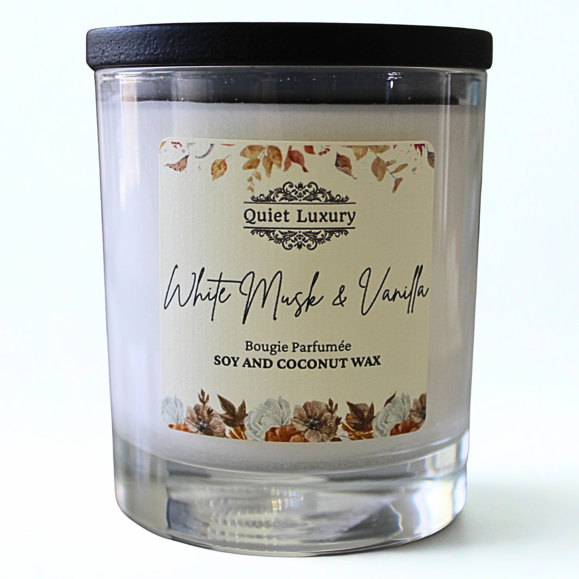 Candle with a label reading 'Quiet Luxury White Musk & Vanilla' on a white background