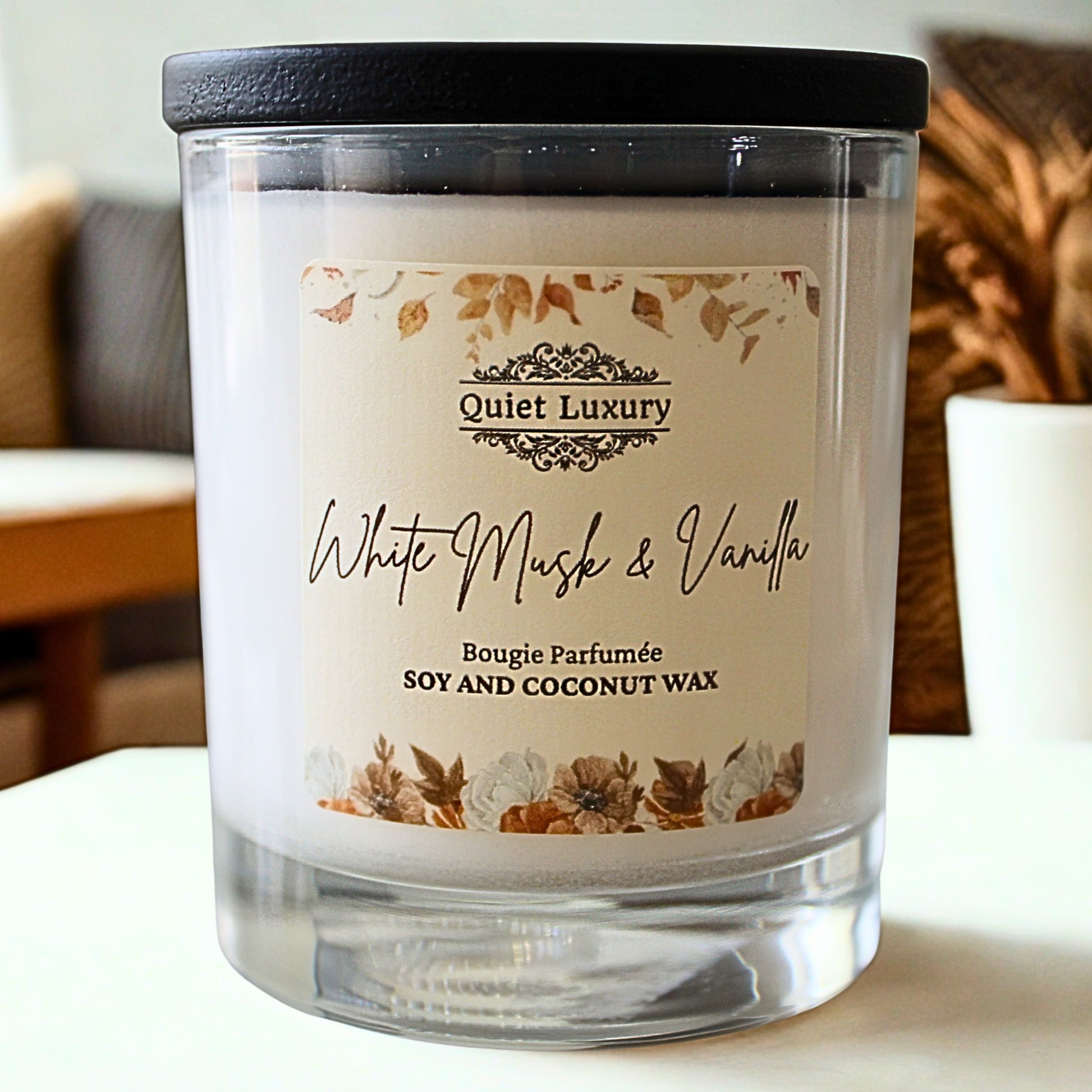 Candle with 'Quiet Luxury' label on a blurred indoor background white musk and vanilla